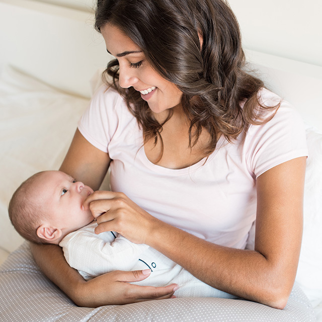 Baby holding ear while feeding