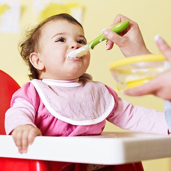 Mother feeding baby food