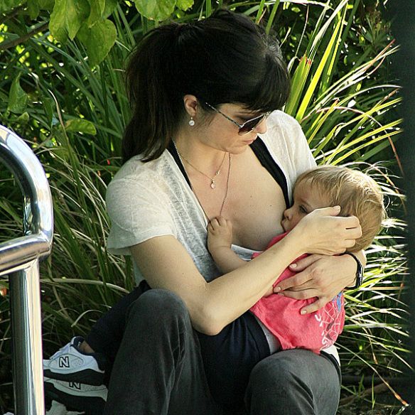 Girl breast feeding baby at graduation