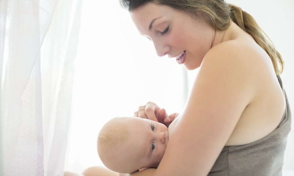 Baby massaging breast while feeding